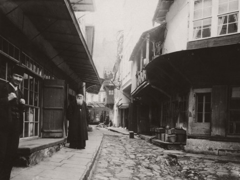 harry-griswold-dwight-locals-stand-outside-storefronts-and-houses-on-karyes-main-street-mount-athos-greece-1916